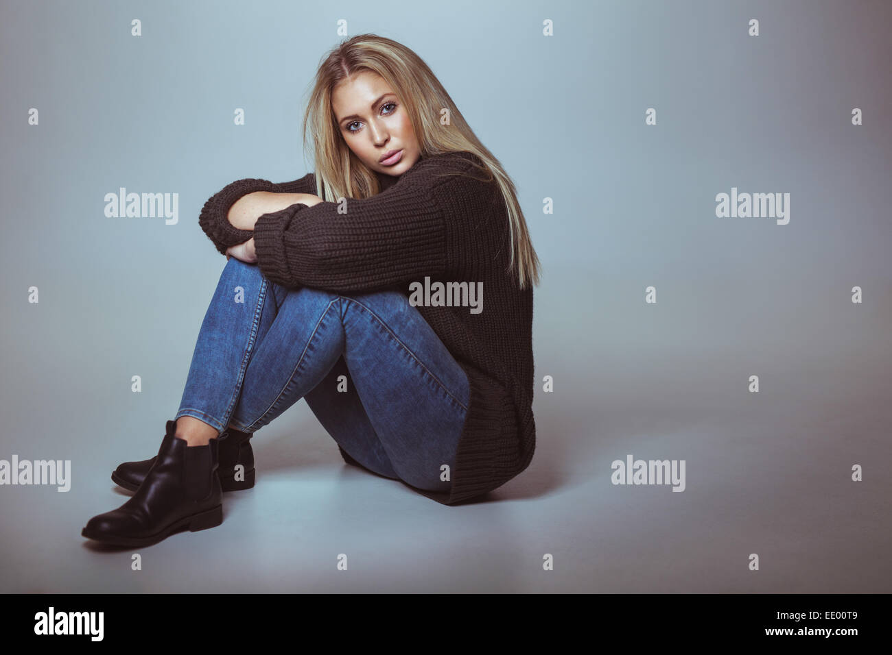 Woman sitting floor studio shot hi-res stock photography and images - Alamy