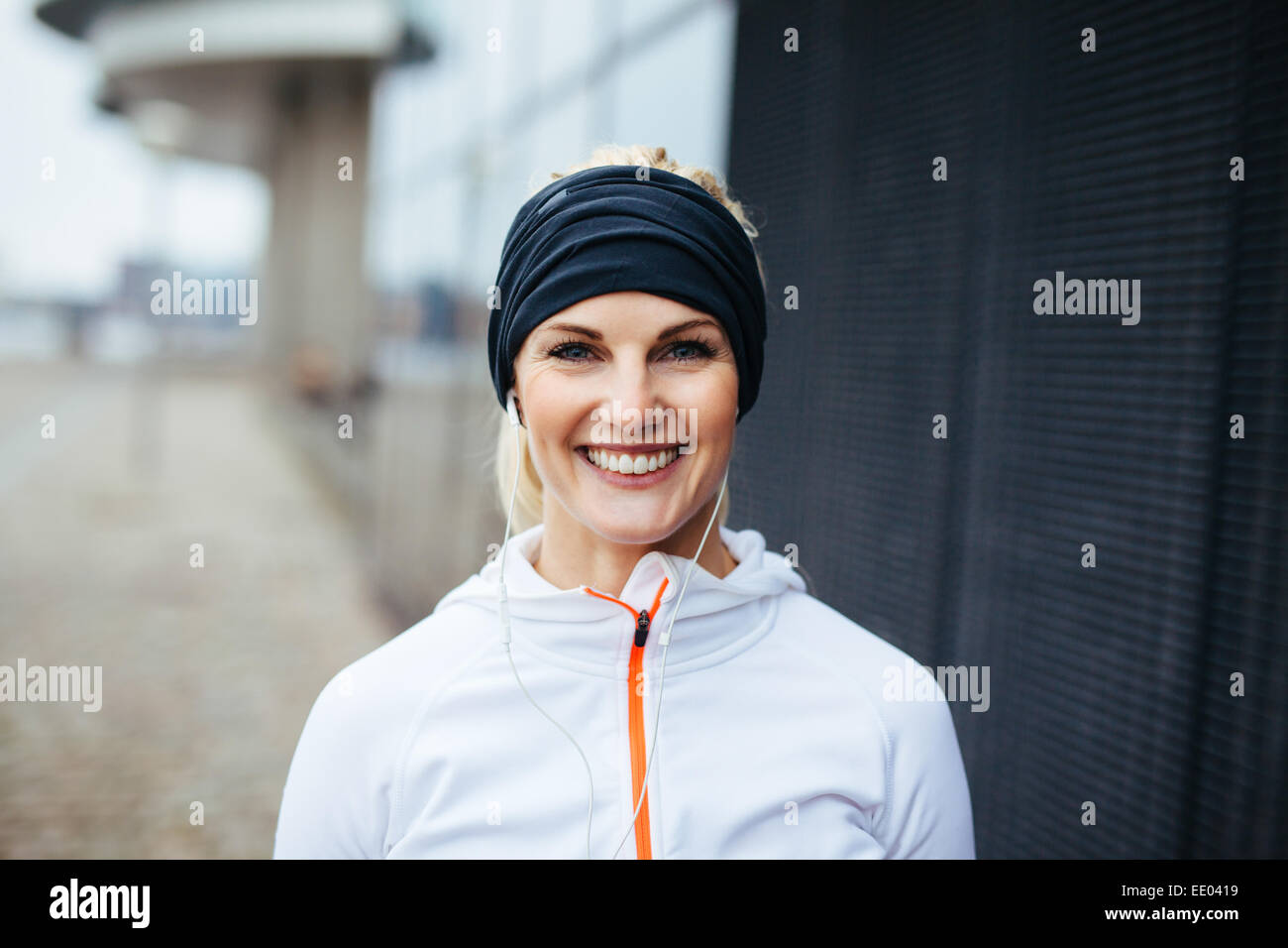 Portrait of cheerful young fitness woman. Smiling young female athlete in sports wear outdoors. Stock Photo