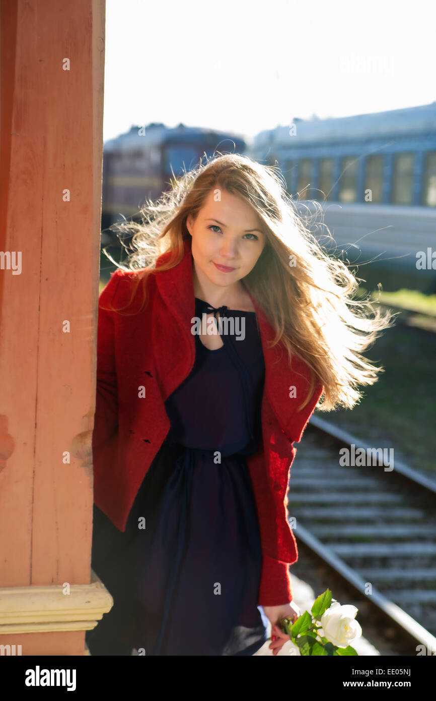 Young woman on train station and white rose Stock Photo - Alamy