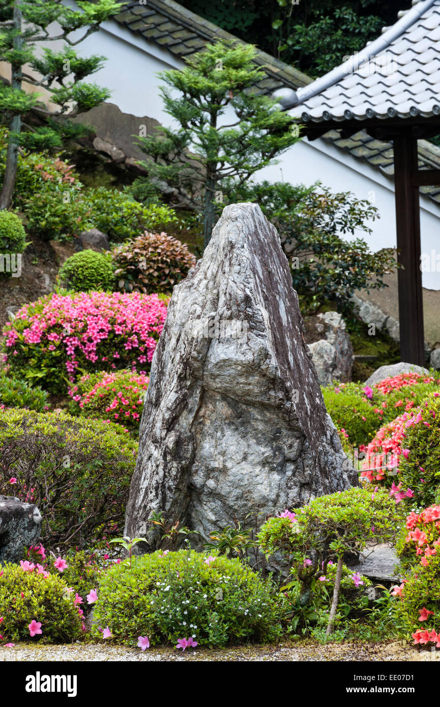 Kaisan-do zen temple, Tofuku-ji, Kyoto, Japan. A rock in the temple garden, surrounded by flowering azaleas Stock Photo