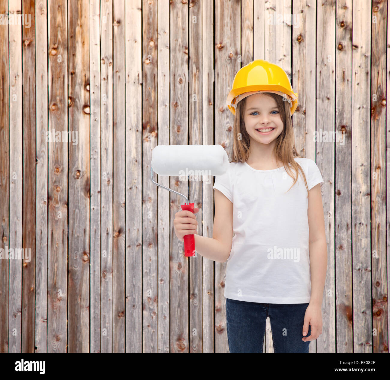 smiling little girl in helmet with paint roller Stock Photo