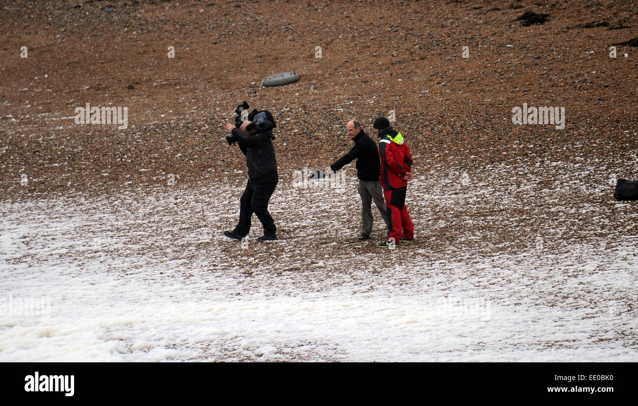 Brighton, UK. 12th January, 2015. UK Weather: A television crew filming the waves on Brighton beach as bad weather batters the south coast today. Stock Photo