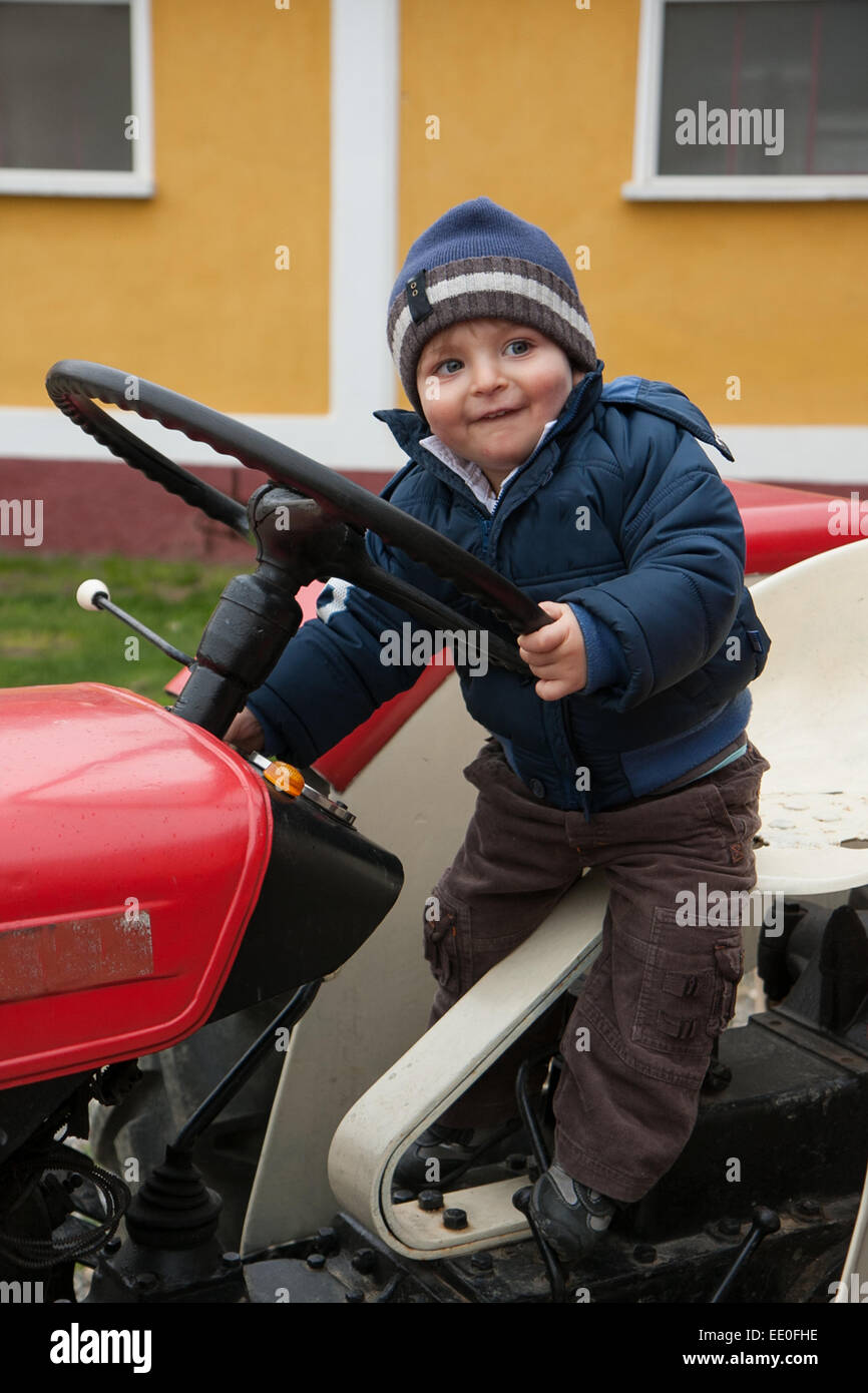 baby with hat driving a tractor old Stock Photo Alamy