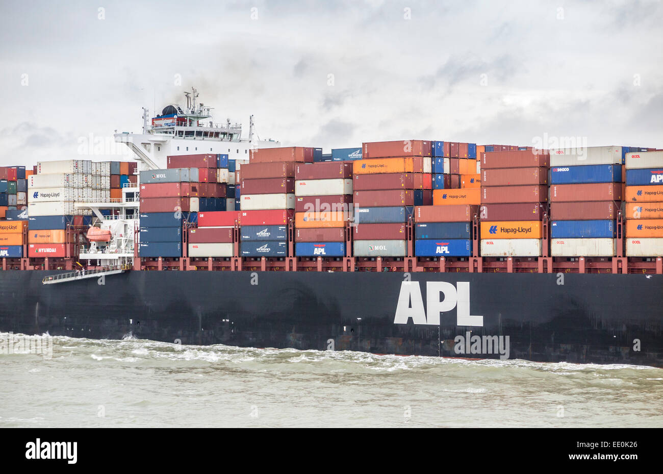 Container ship 'APL Gwangyang' loaded with multi-coloured containers stacked on deck, underway sailing in Southampton Water, the Solent, Hampshire, UK Stock Photo