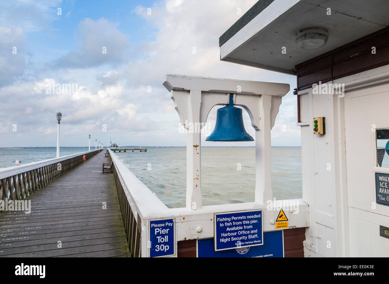 Blue bell at the entrance to the traditional old-fashioned Yarmouth Pier, Yarmouth, Isle of Wight coast, UK, overlooking the Solent Stock Photo