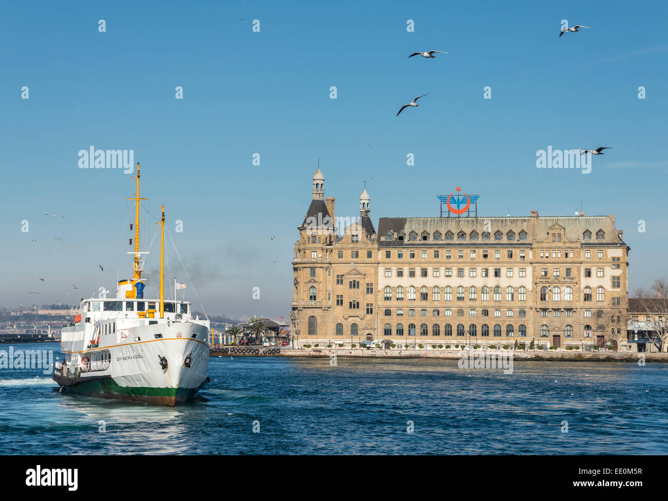 A passenger ferry arriving at Kadikoy on the Asian side of Istanbul with Haydarpasa railway station in the background, Turkey. Stock Photo