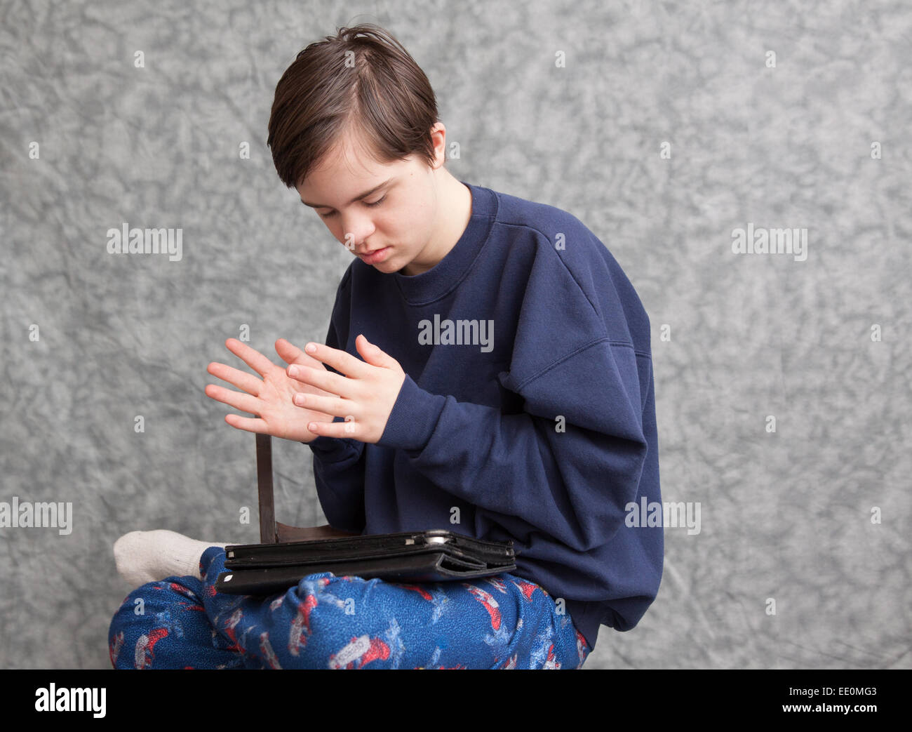 Teenage Boy with autism and Down's Syndrome clapping his hands as he