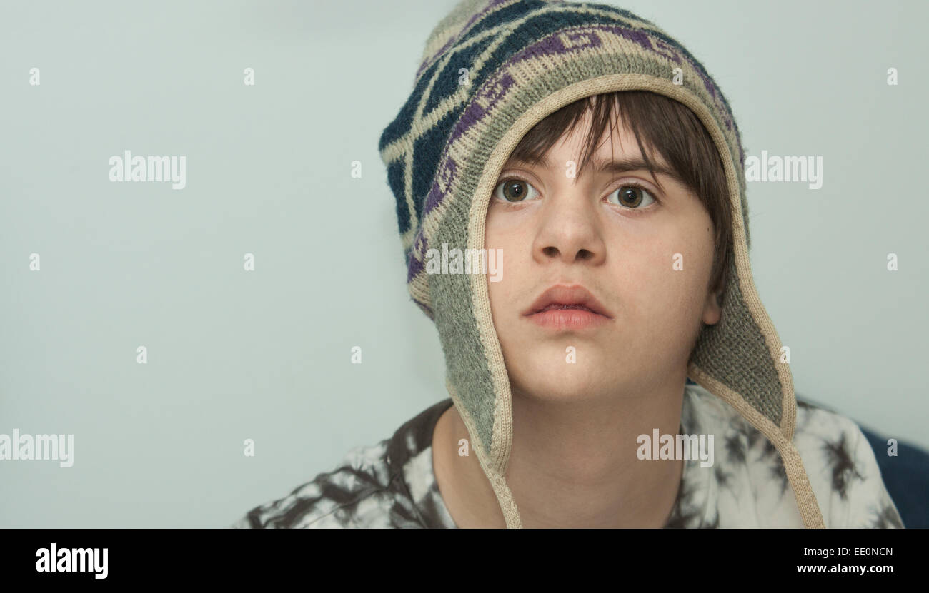 Serious Teenage boy with Autism and Downs Syndrome wearing a Wool Hat Stock Photo