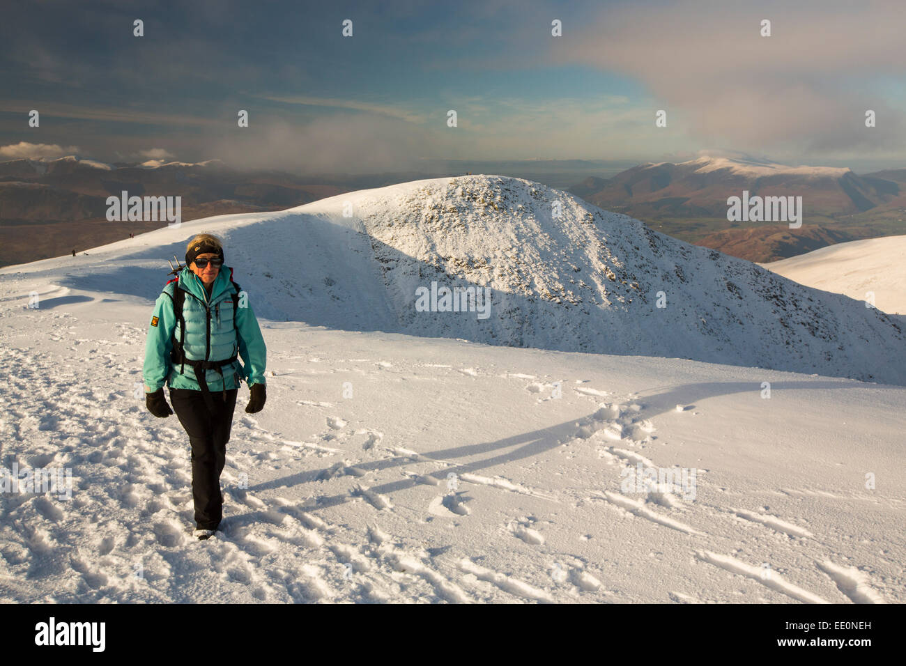 A female walker on Helvellyn summit in winter conditions, Lake District, UK. Stock Photo