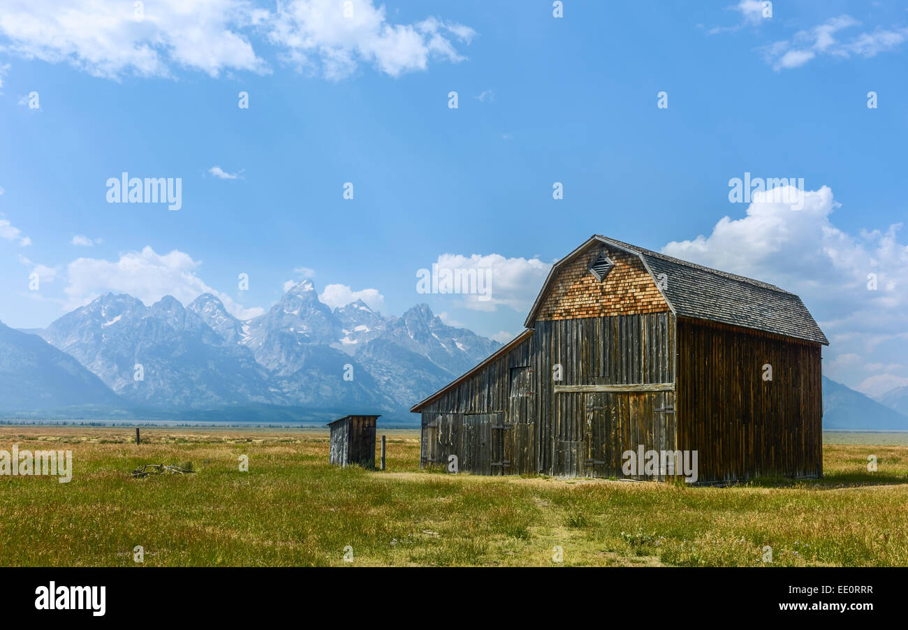 Derelict barns of early Mormon community set against the Grand Tetons on a bright sunny day, Mormon Row, Packston, Wyoming, USA. Stock Photo