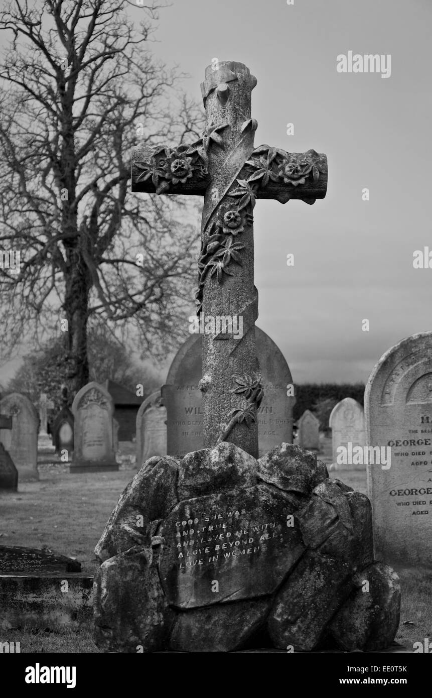 Ornate cross gravestone with message of love. Monochrome. Message repaired digitally. Stock Photo