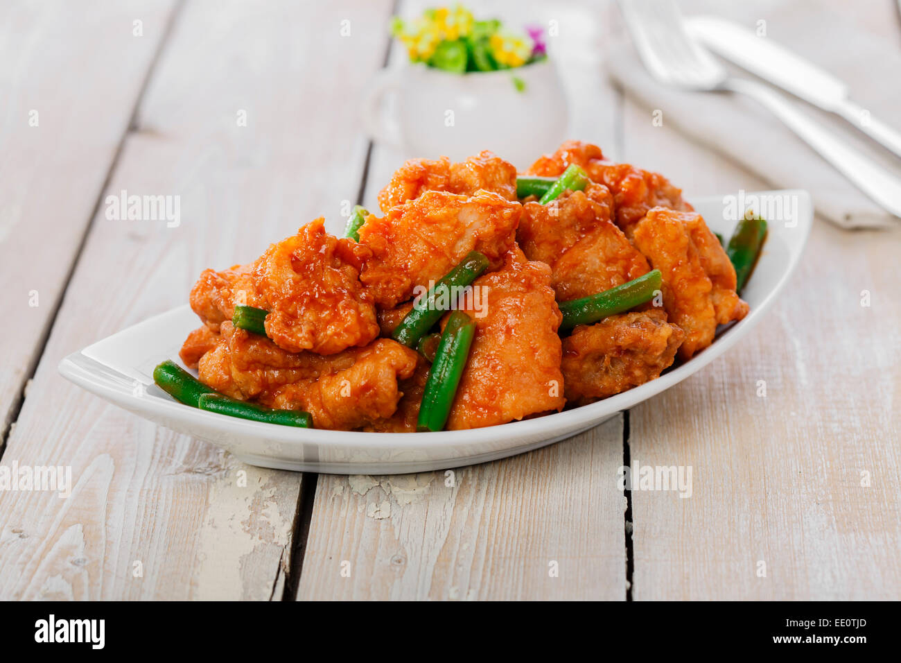 pieces of chicken in batter with spicy sauce and green beans Stock Photo