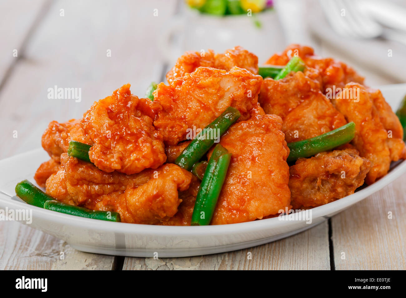 pieces of chicken in batter with spicy sauce and green beans Stock Photo