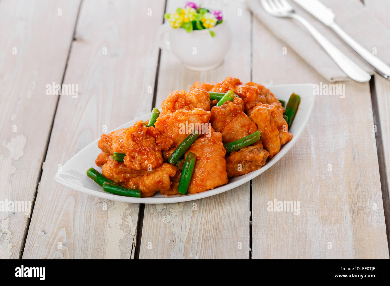 pieces of chicken in batter with spicy sauce and green beans Stock Photo