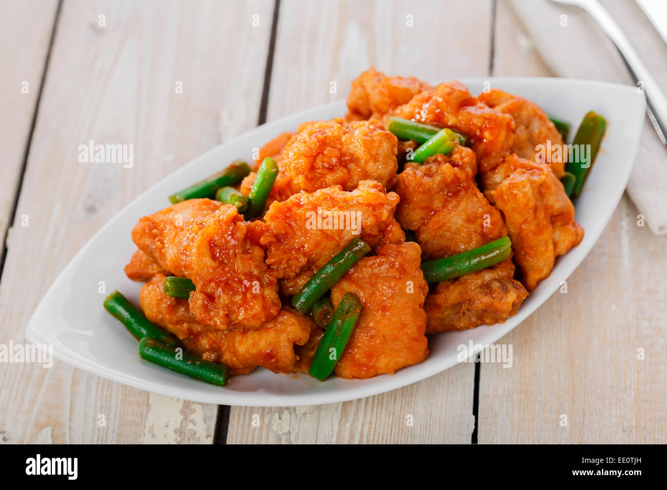 pieces of chicken in batter with spicy sauce and green beans Stock Photo