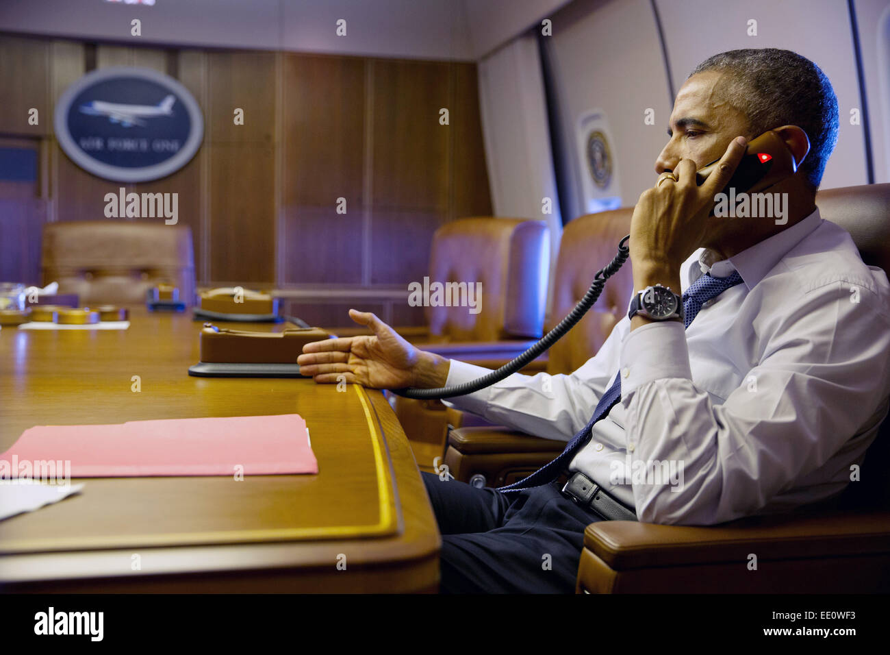 US President Barack Obama talks on the phone with French President Francois Hollande to offer his support and condolences following the mass shooting by Islamic terrorists at Charlie Hebdo magazine January 7, 2015 from aboard Air Force One. Stock Photo