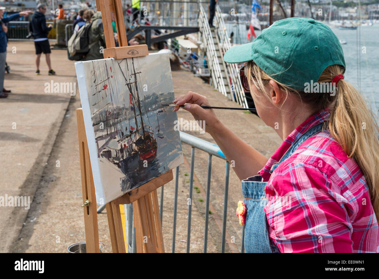 Women painting a picture of Tall Ships moored in Falmouth Harbour during the 2014 Tall Ships Regatta - EDITORIAL USE ONLY Stock Photo