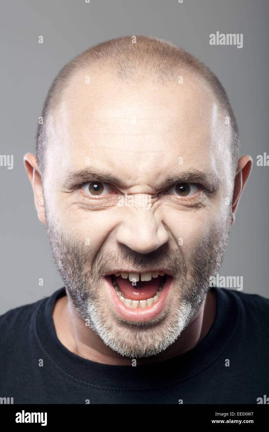 portrait of angry man screaming isolated on gray background Stock Photo