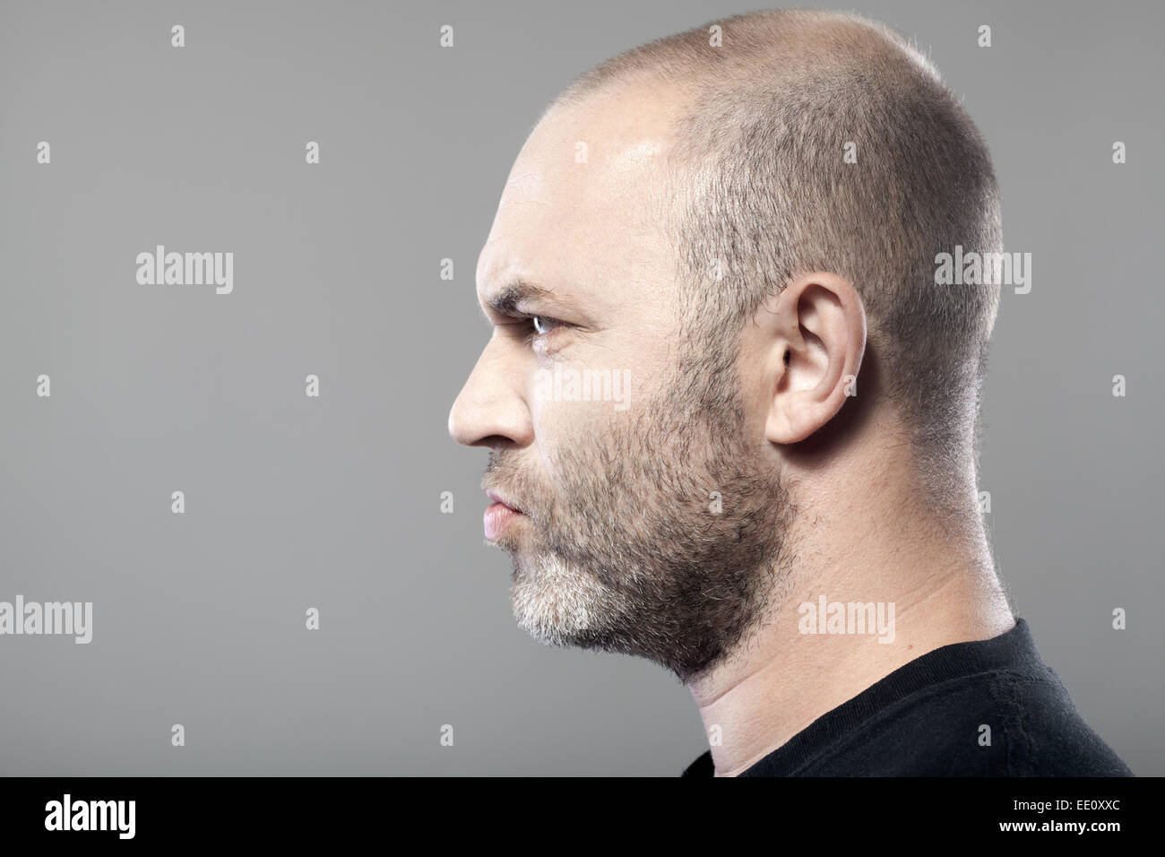 side portrait of gloomy man isolated on gray background with copyspace Stock Photo