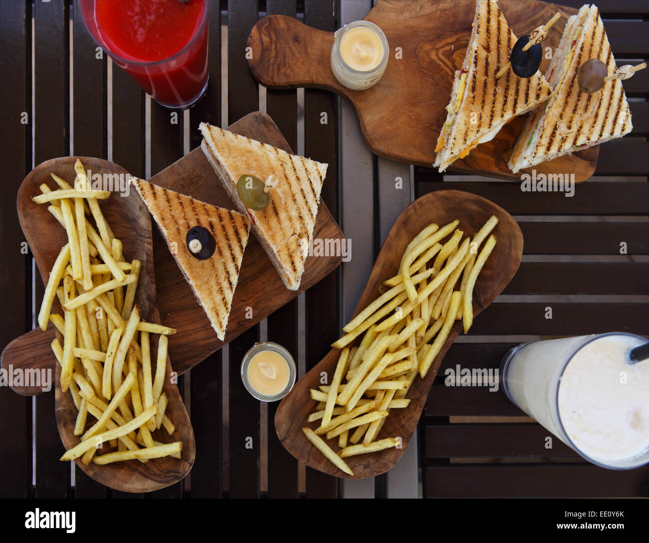 Chicken club sandwiches and french fries with juice and shake on the