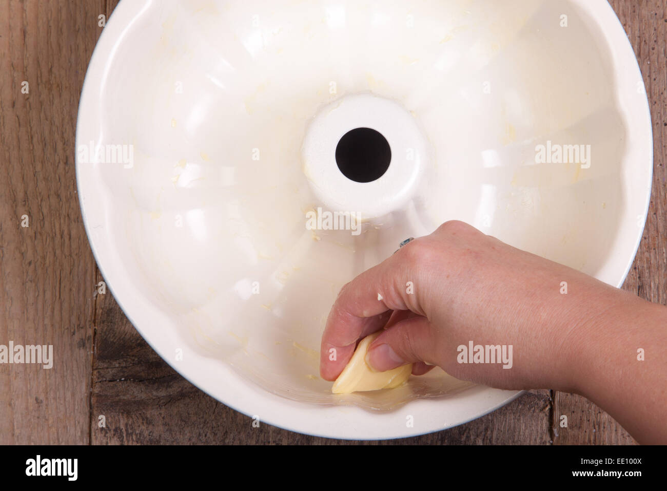 Greasing cake pan with margarine or butter, making bundt cake Stock Photo
