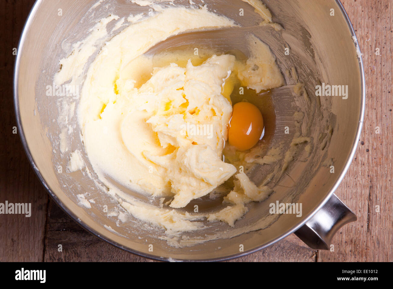 adding one egg to mixed butter with sugar Stock Photo Alamy
