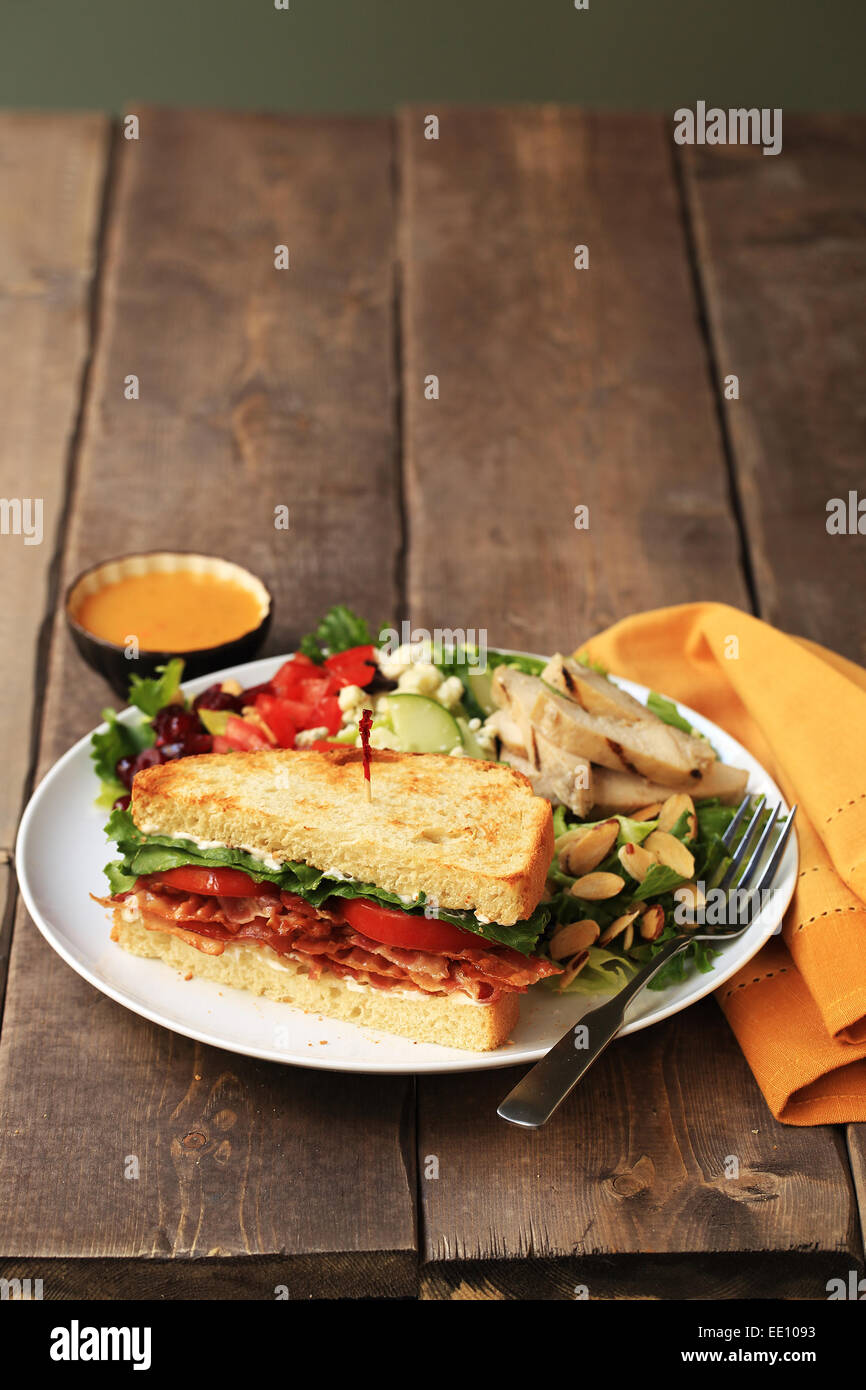 A BLT sandwich, healthy salad and dressing. Stock Photo