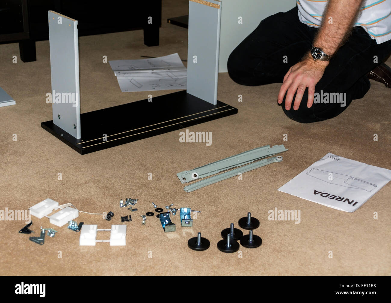 This man is assembling flat-packed furniture. Stock Photo