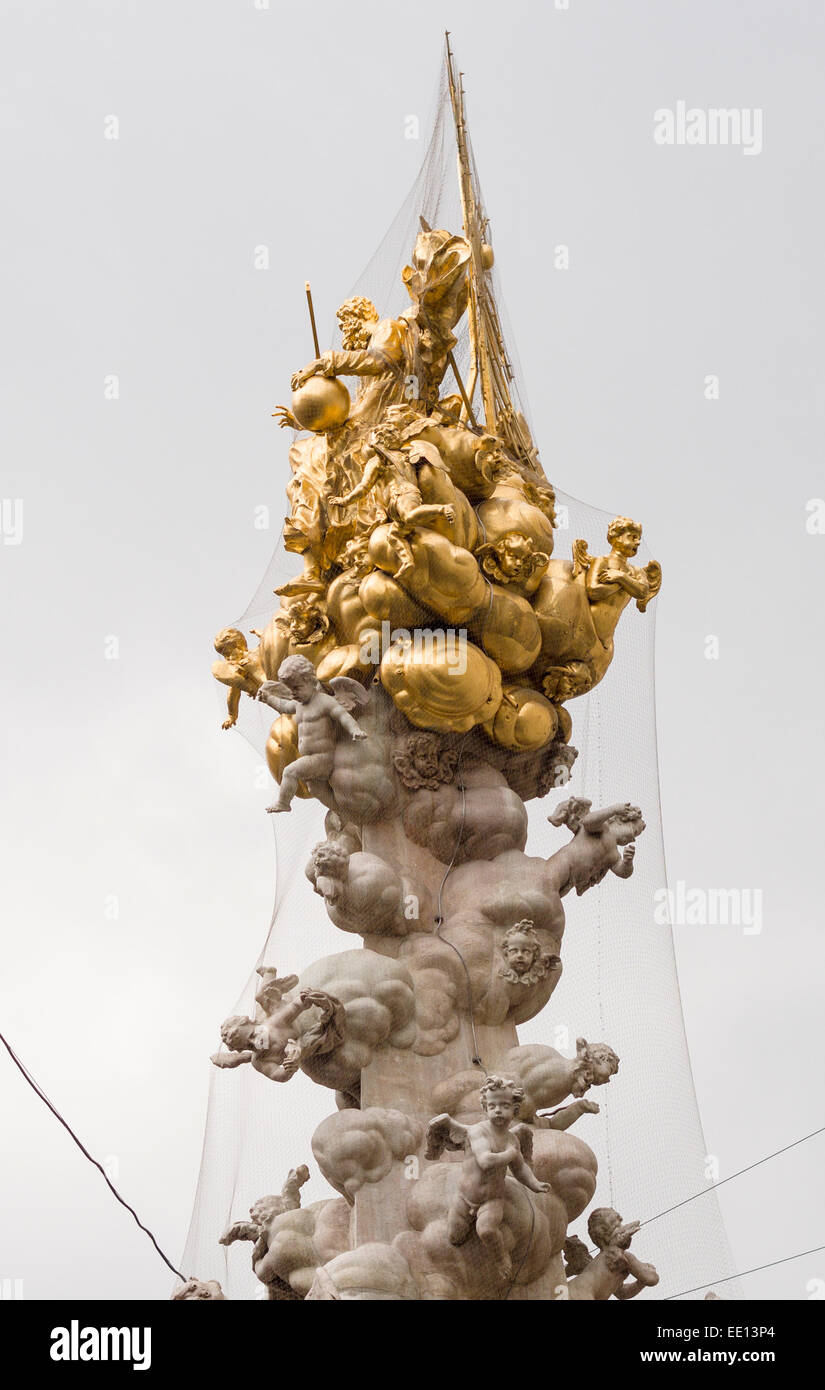 The Gold Pinnacle of the Plague Column in Vienna. Covered in netting to discourage pigeons, it is like a cloud with angels Stock Photo