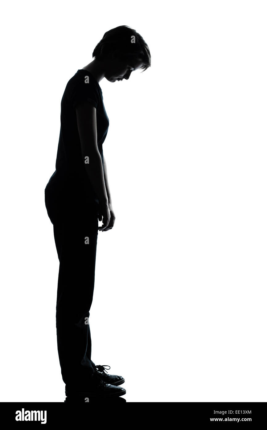 one caucasian young teenager silhouette girl sad looking down  full length in studio cut out isolated on white background Stock Photo