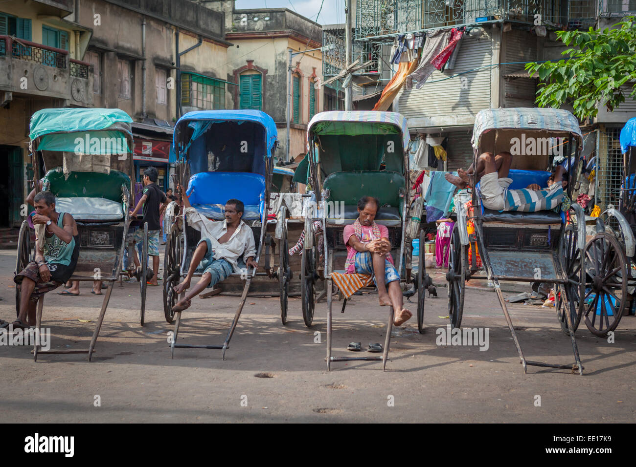 Rickshaw pullers taking a rest on a street close to Kalighat Kali temple in Kolkata, West Bengal, India. Stock Photo