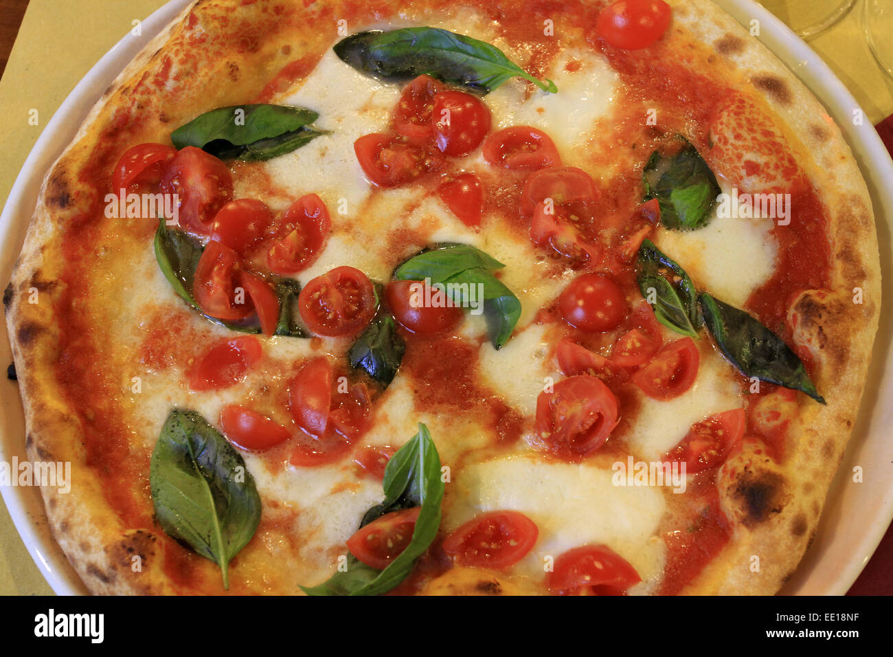 Italienische Spezialität, Pizza mit Tomaten Mozzarella und Basilikum, Italian specialty, pizza with tomatoes, mozzarella and bas Stock Photo