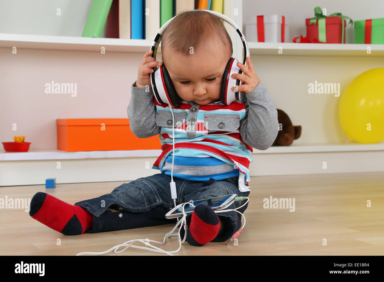 Portrait of a baby listening to music with headphones Stock Photo