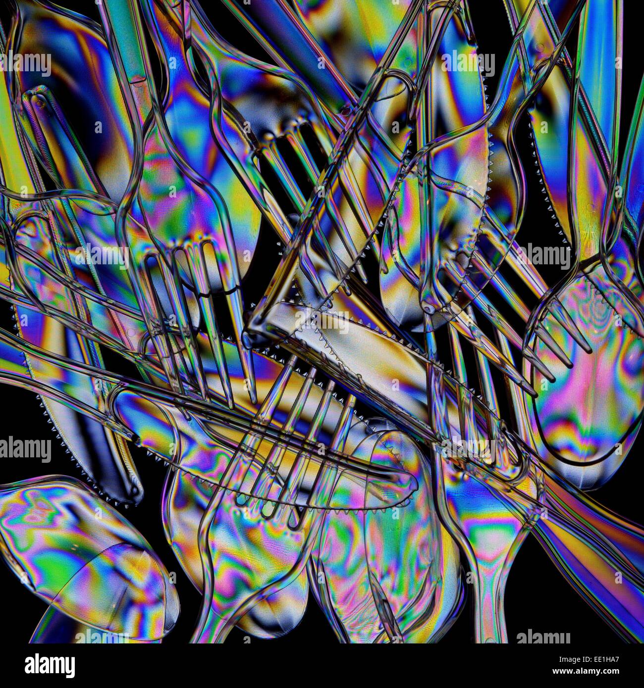 A pile of clear plastic cutlery photographed through polarising filters. Stock Photo