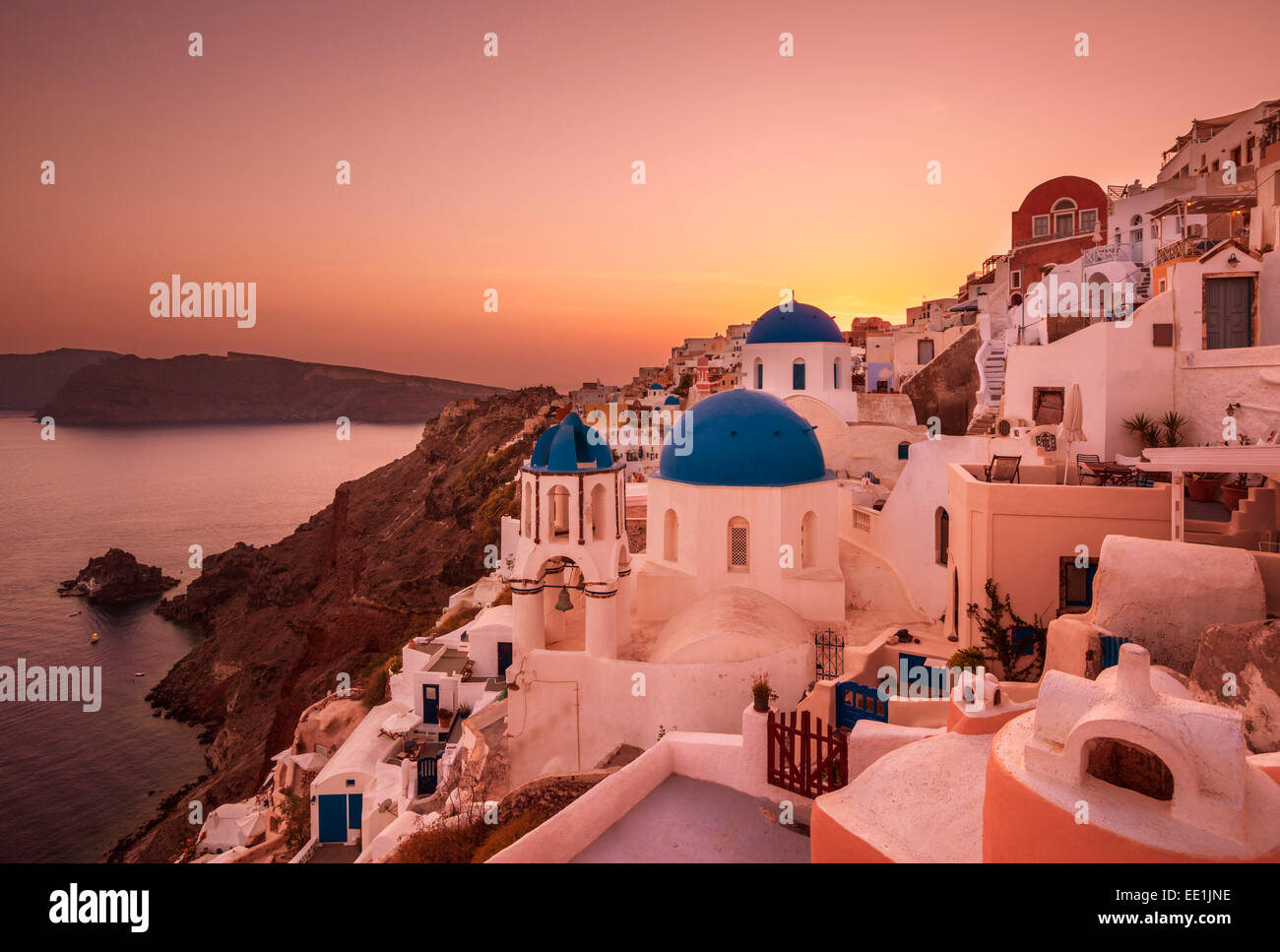 Greek church with three blue domes at sunset, Oia, Santorini (Thira), Cyclades Islands, Greek Islands, Greece, Europe Stock Photo