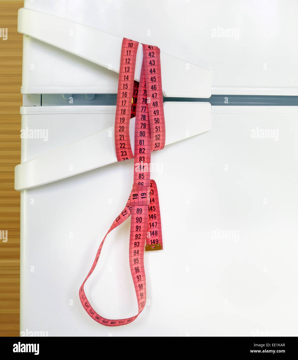 Measuring tape noose on refrigerator door.  Diet and anorexia concept Stock Photo