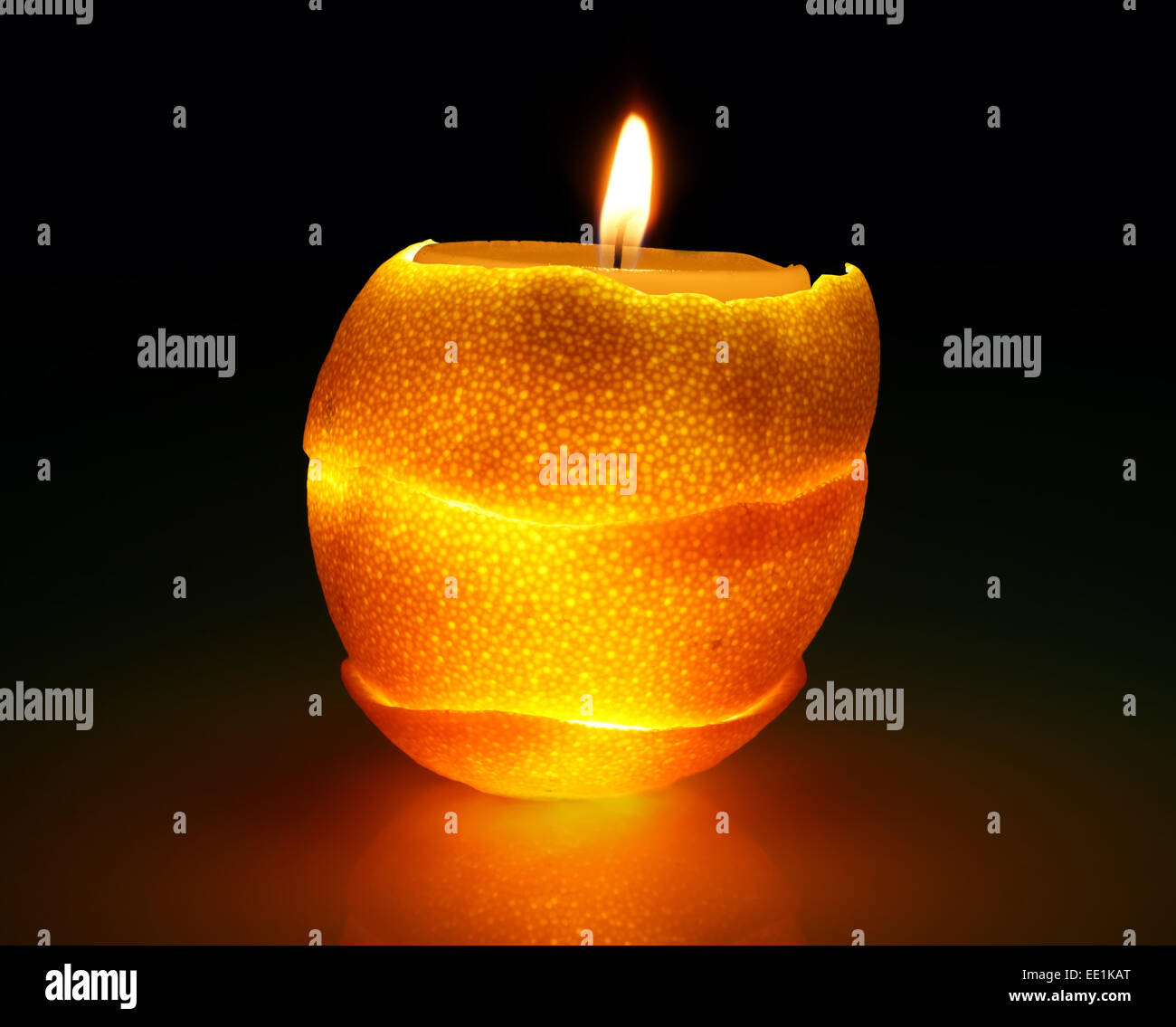Burning candle in orange peel.   romantic  decoration. Stock Photo