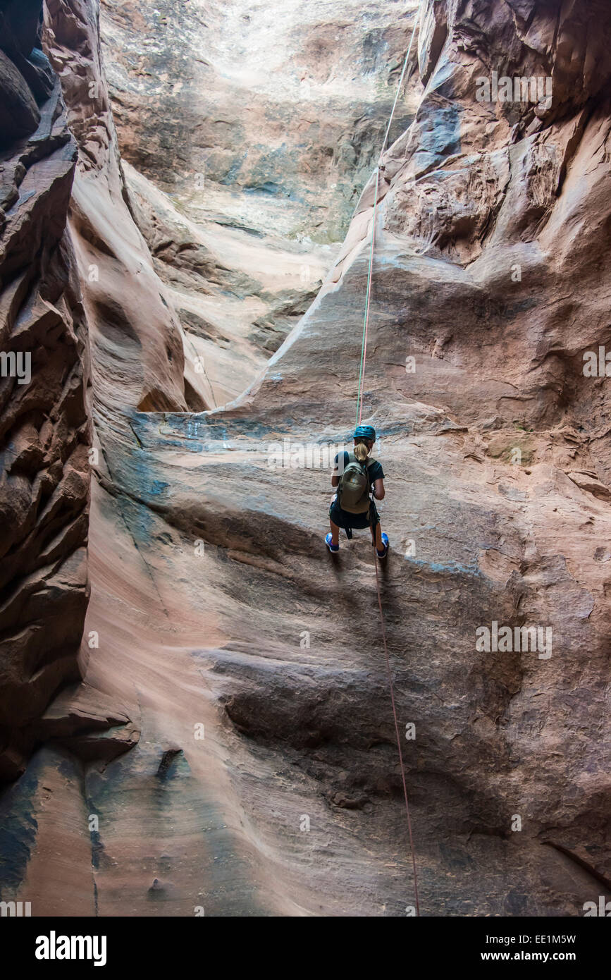 Woman rapelling down in slot canyon, canyoneering, Moab, Utah, United States of America, North America Stock Photo