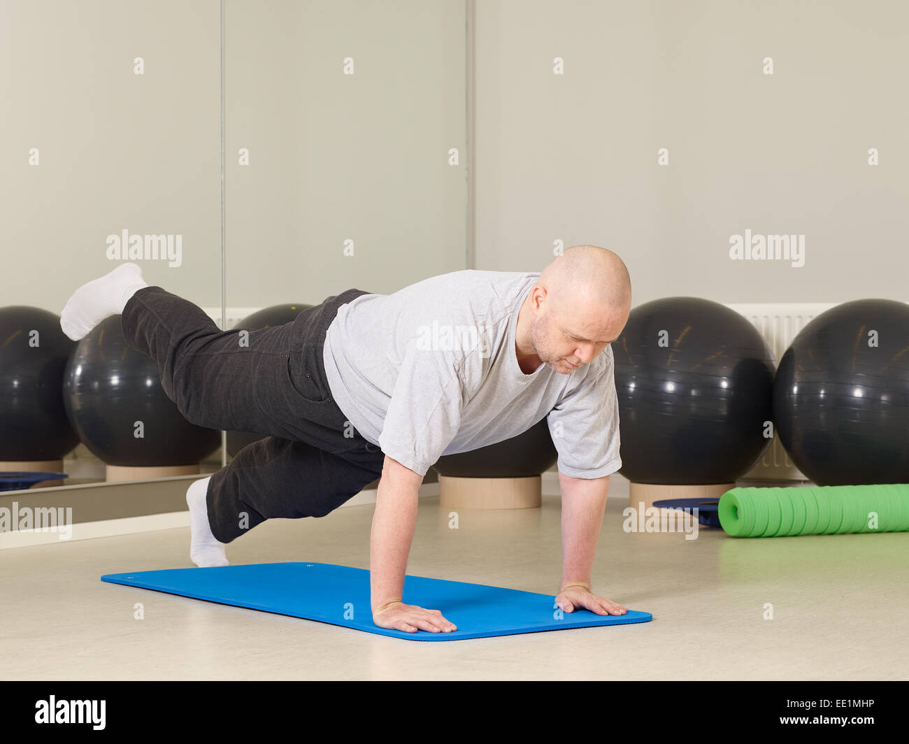 Mature man takes care of his health, he exercise pilates and stretching in a gym Stock Photo