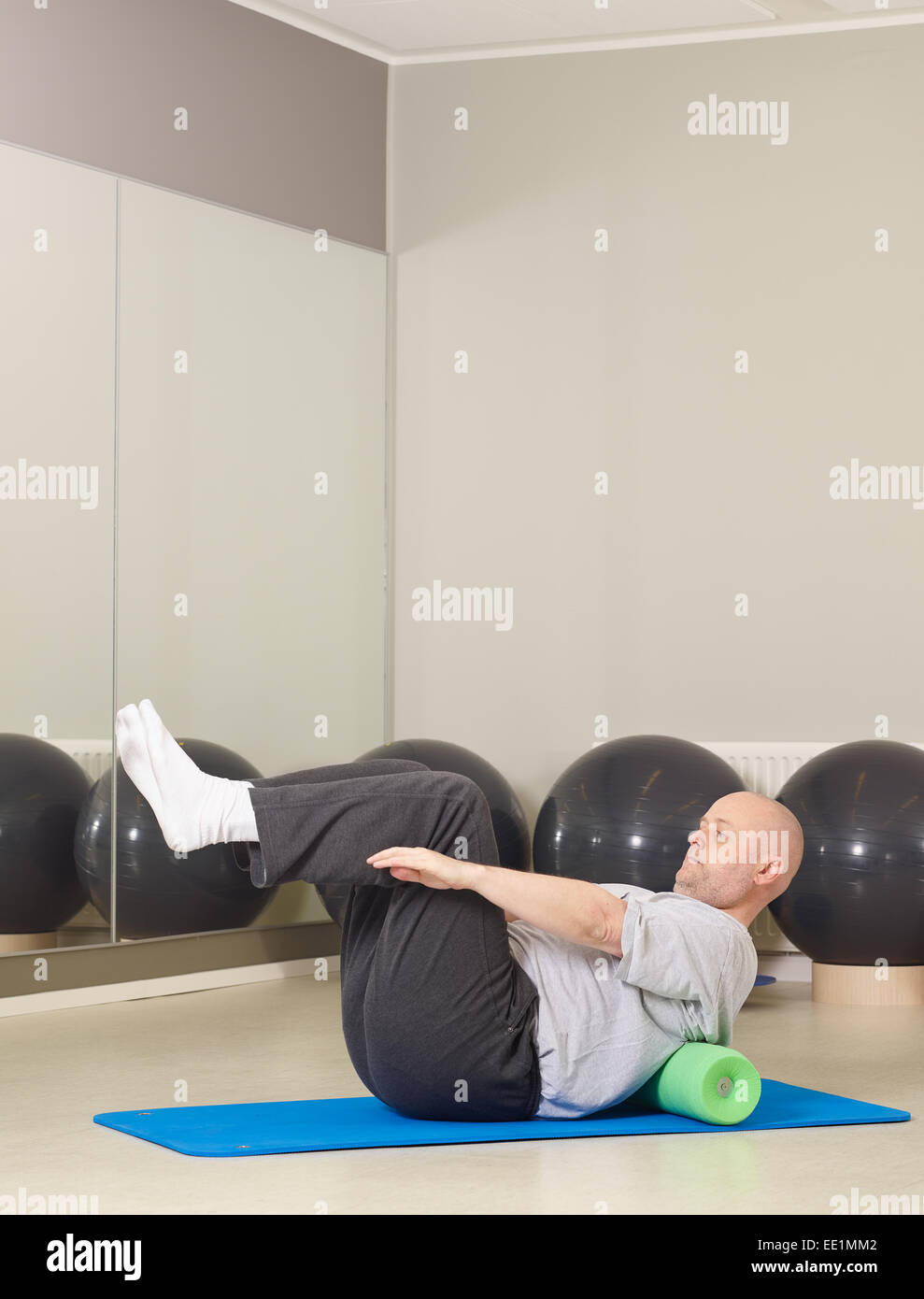 Mature man takes care of his health, he exercise pilates and stretching in a gym Stock Photo