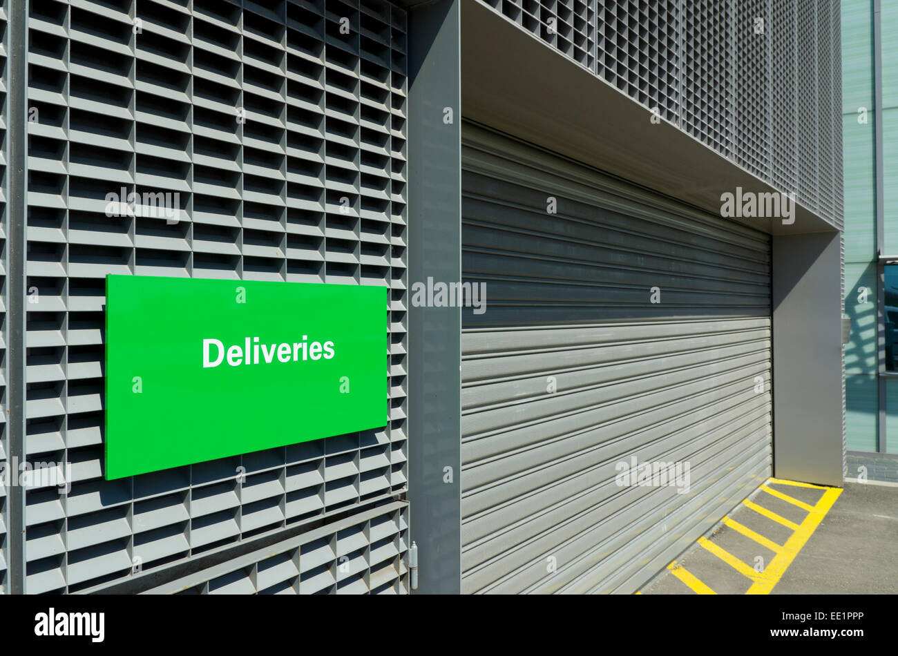 warehouse entrance with green deliveries sign Stock Photo