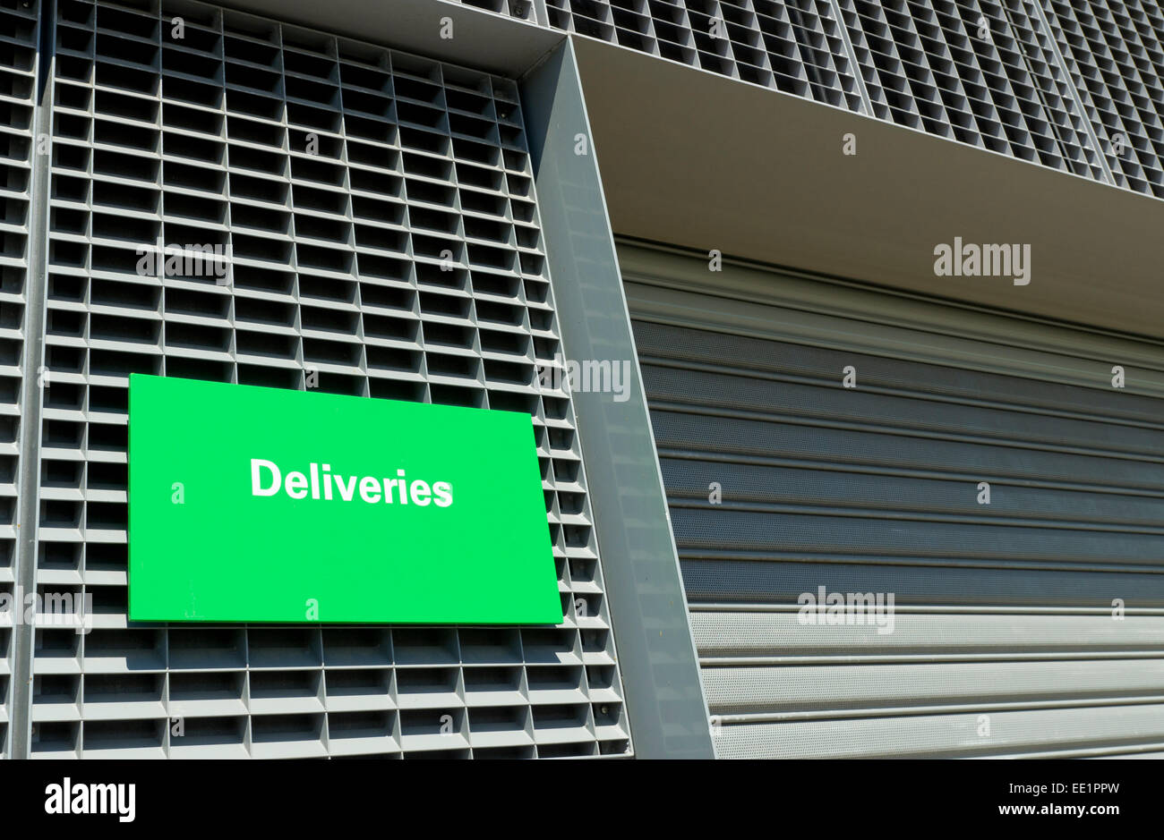warehouse entrance with green deliveries sign Stock Photo