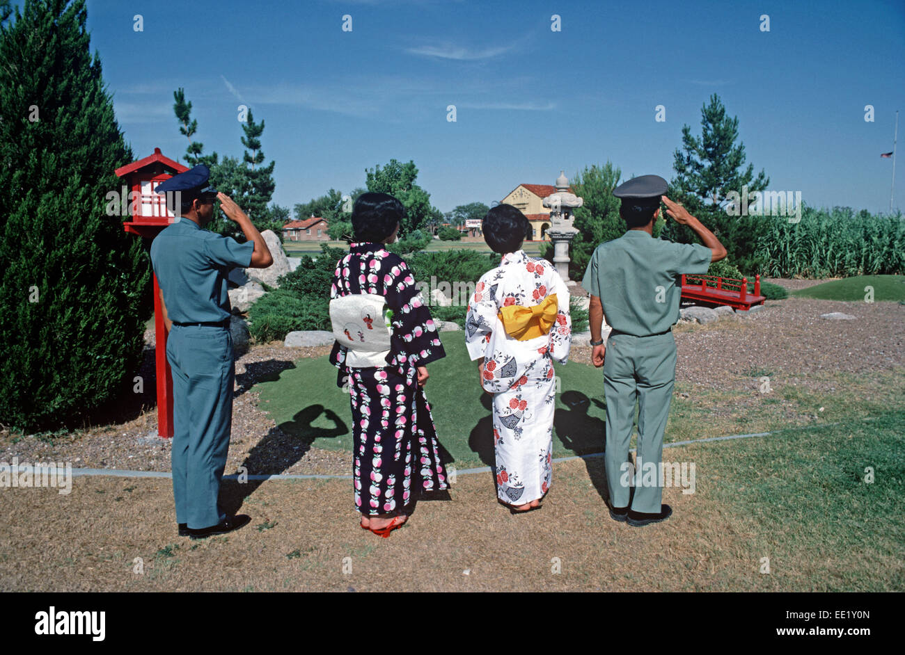 JAPANESE MILITARY PERSONNEL AND WIVES SALUTING THE RAISING OF THE FLAG IN JAPANESE GARDEN, FORT BLISS, TEXAS, UNITED STATES ARMY, USA Stock Photo