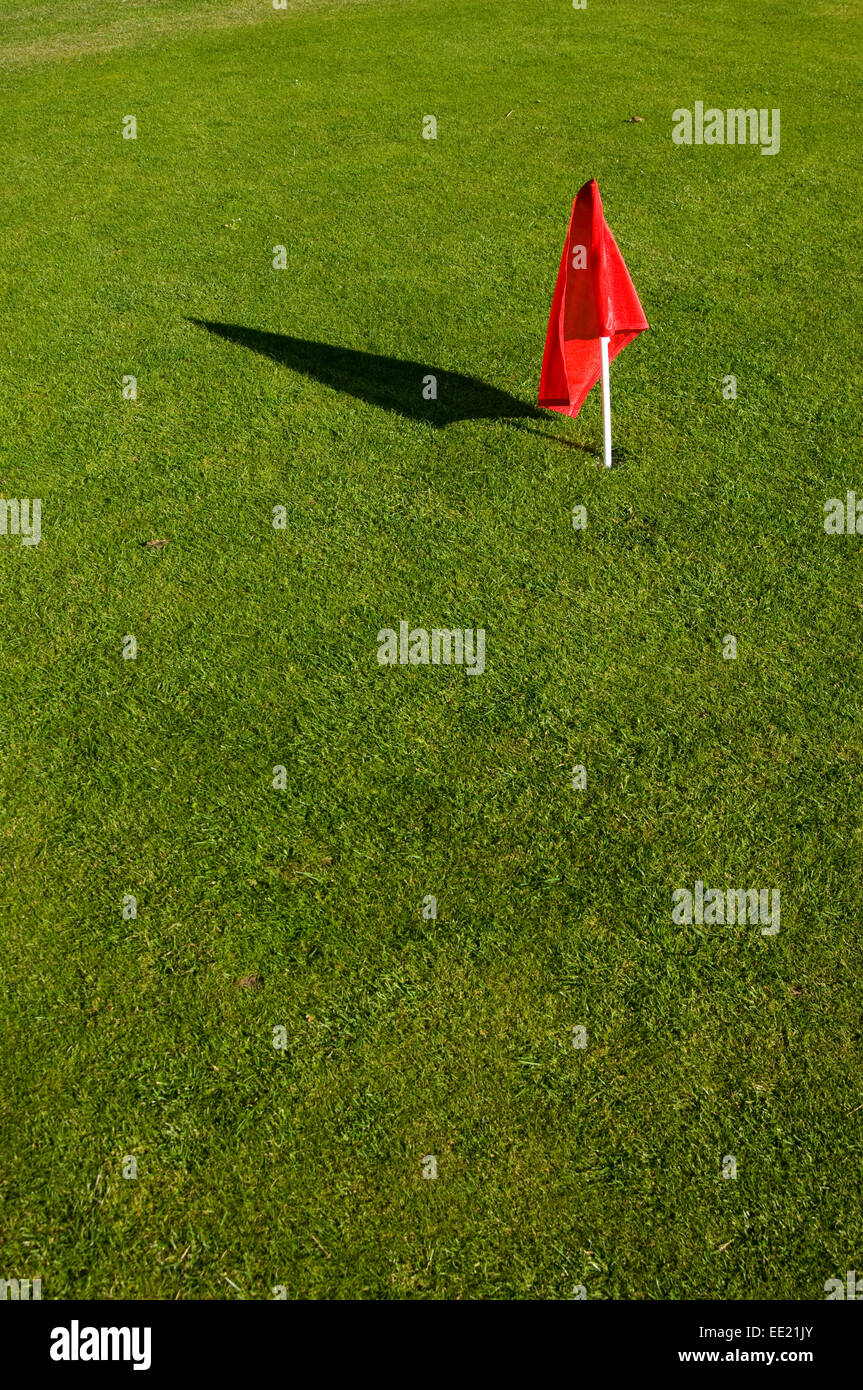 red golf flag on green grass Stock Photo
