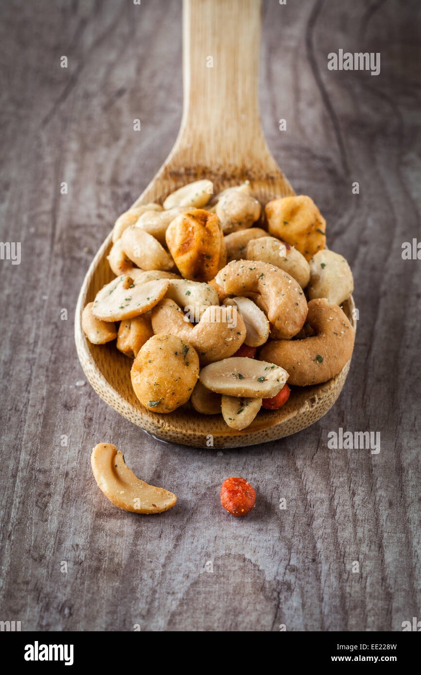 Salty appetizer snacks on a wooden spoon Stock Photo