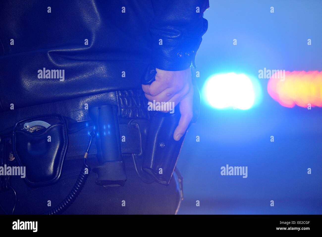 A policeman grabs his pistol, Germany, city of Braunlage, 12. January 2015. Photo: Frank May Stock Photo