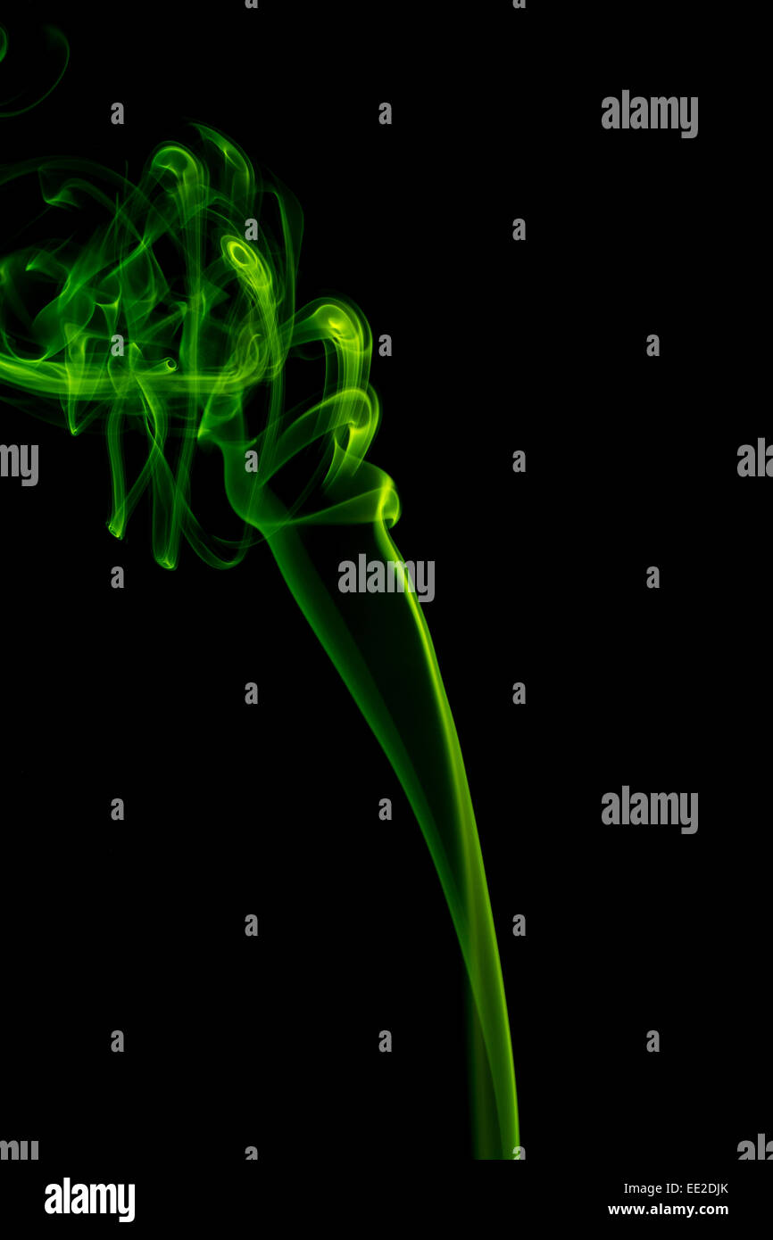 Abstract smoke pattern.  Green smoke on a black background, taken in vertical format. Stock Photo