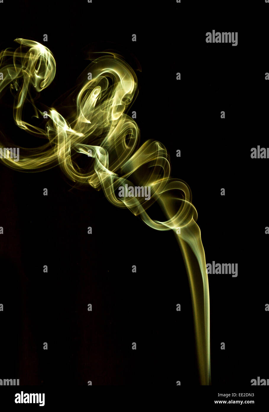 Abstract smoke pattern.  Yellow smoke on a black background, taken in vertical format. Stock Photo