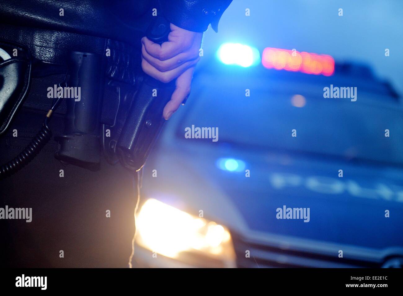 A policeman grabs his pistol, Germany, city of Braunlage, 12. January 2015. Photo: Frank May Stock Photo