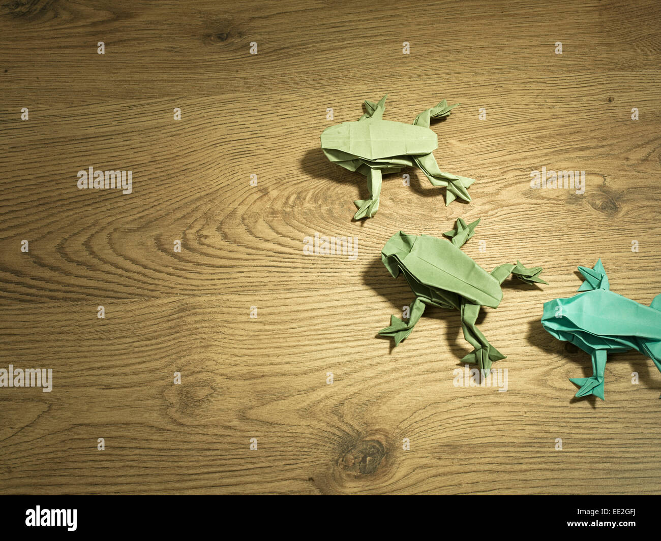 Green origami frogs on wooden surface Stock Photo Alamy